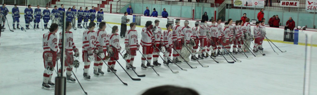 The two teams stand on the line during the National Anthem for the game to start. |Tess McDonald