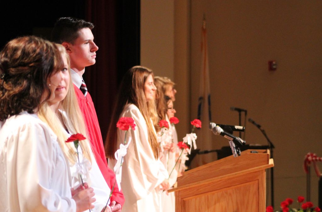 Seniors performing in the Baccalaureate ceremony stand on stage after walking in. | by Siobhan Richards 