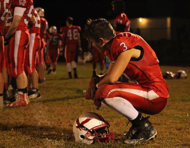 Senior Alec Dalton solemnly watches as the clock winds down. The score remains 14-6. | by Siobhan Richards 
