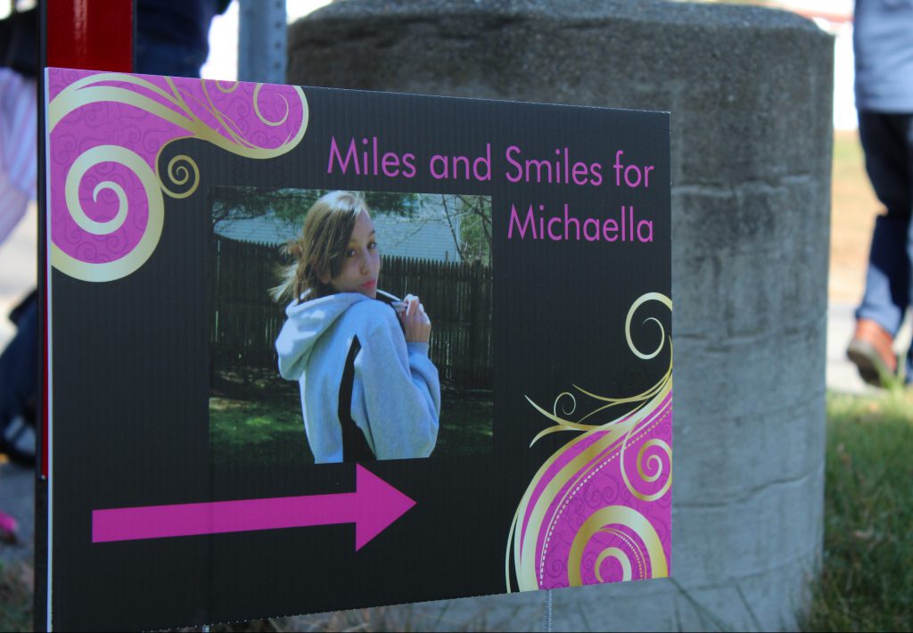 Signs posted along the walk guiding participants through the race depict Michaella throughout her life. | by Siobhan Richards