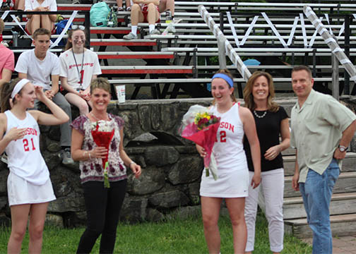 Girls Lacrosse Seniors stand with their parents and receive flowers as part of Senior Night Festivities I by John Houle