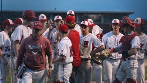 Hawks huddle on the sideline as they go into the 5th inning |by Audrey De Zutter 