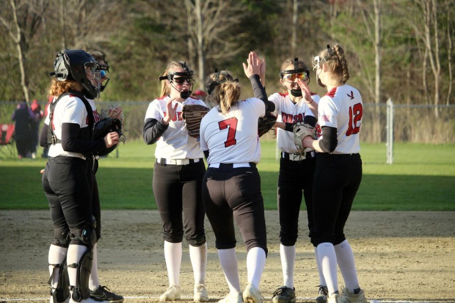 Starting in-fielders high fiving before inning |by Brianna Devlin