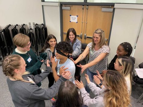 Lucas Pessoni in the center of a trust fall circle with Millie Olinciw-Olkuski, Anlina Chen, Kaya Bairos, Jalissia Dawes, Ms. S, Lucas Micciche, Yasmin Andrade and Yasmim Bicalho | photo provided by Ms. Bradford