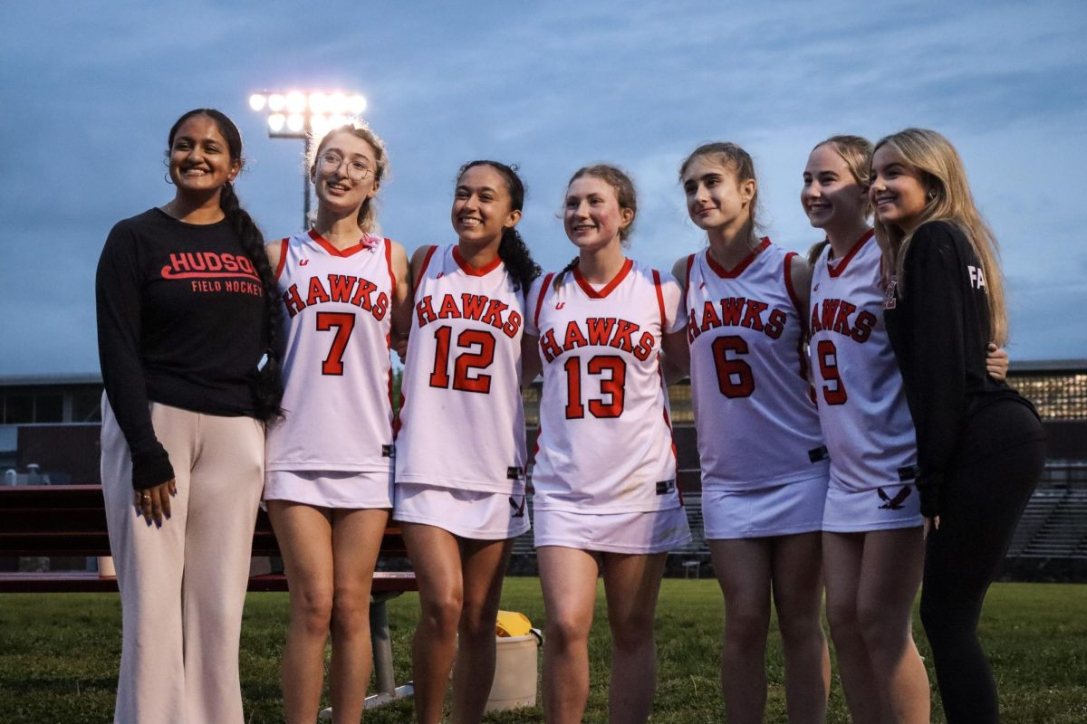 Girls Varsity Lacrosse Senior players and team managers smile for a photo at their senior night |by Ella Spuria