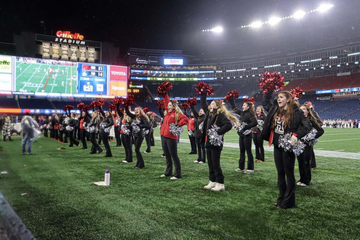 Varsity Cheerleading leads the crowd on the sidelines |by Ella Spuria