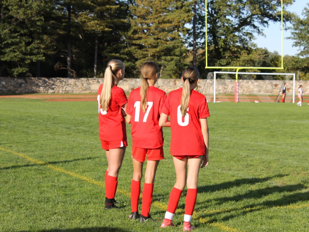 Sophomore Regina Parham, 19, Freshman Charlotte Sheehy, 6, and 8th Grader Kiera Farhety, 17 all waiting to be subbed in 