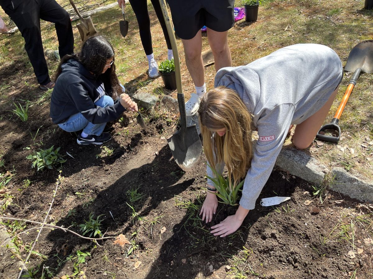 Freshman Daphney DaCosta and Reese Concannon planting pollinator garden 